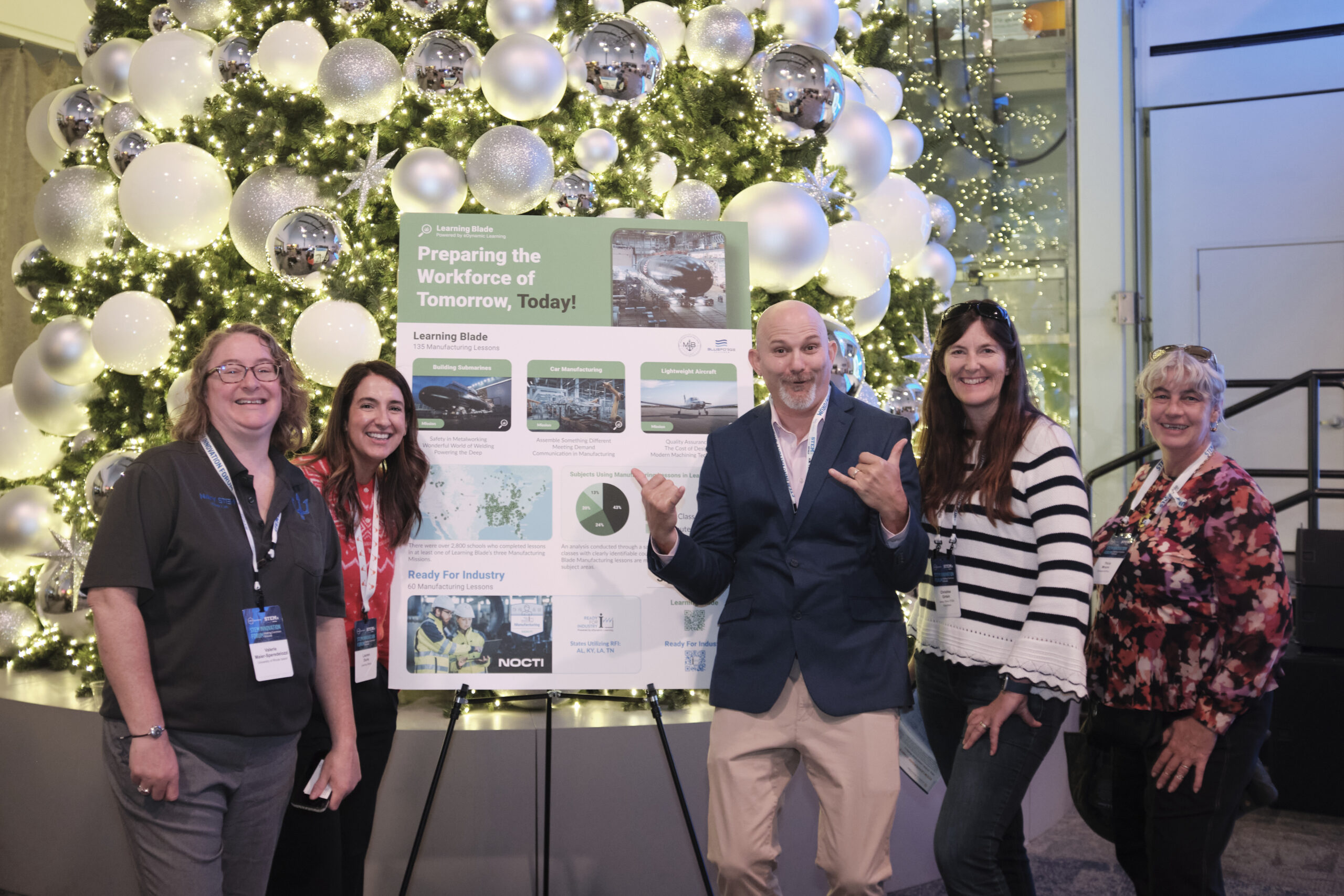 Group of people posing in front of a poster