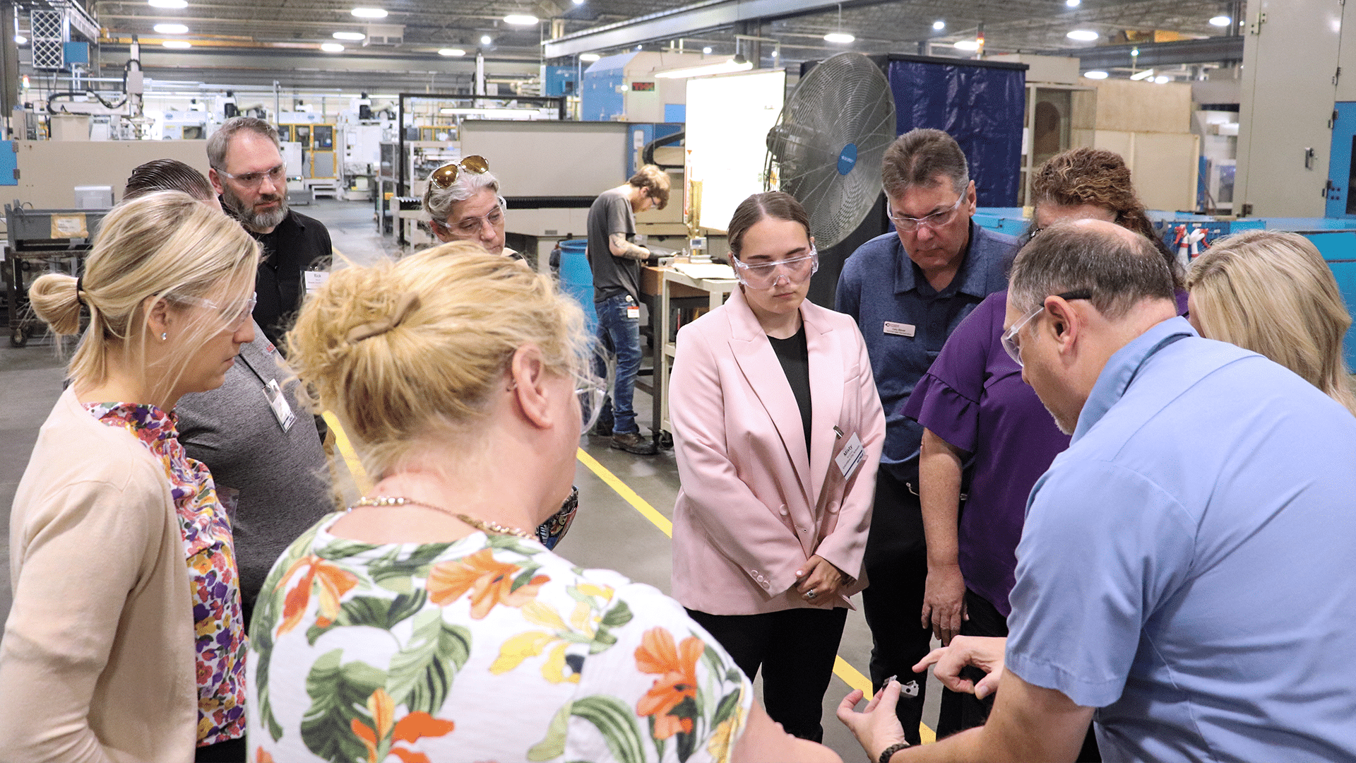 A man describes a device to others standing around him