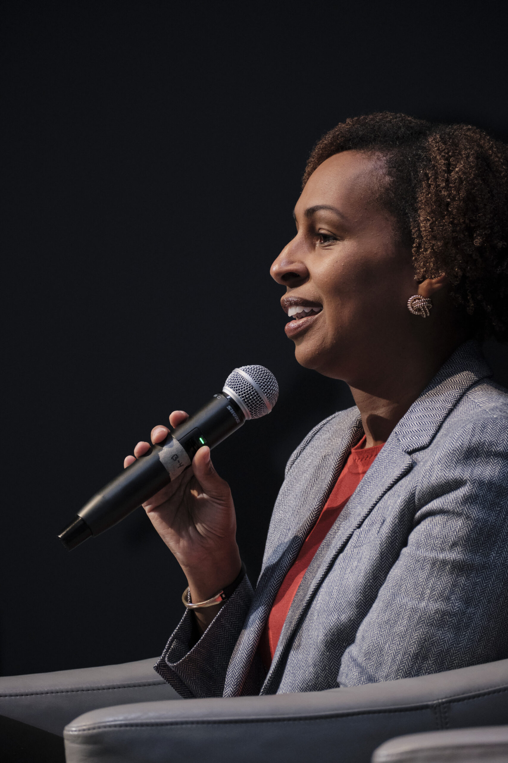 Female speaker sitting in a chair on a stage