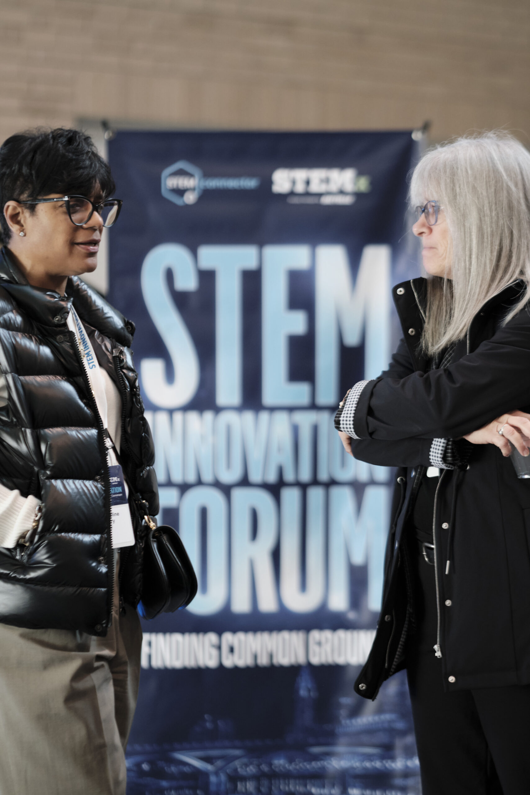 Two people networking in front of a StemX banner