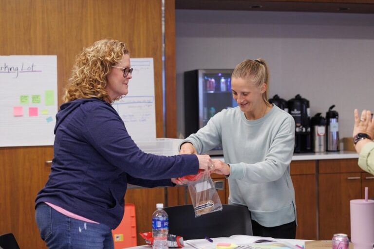 Two women filling a plastic bag
