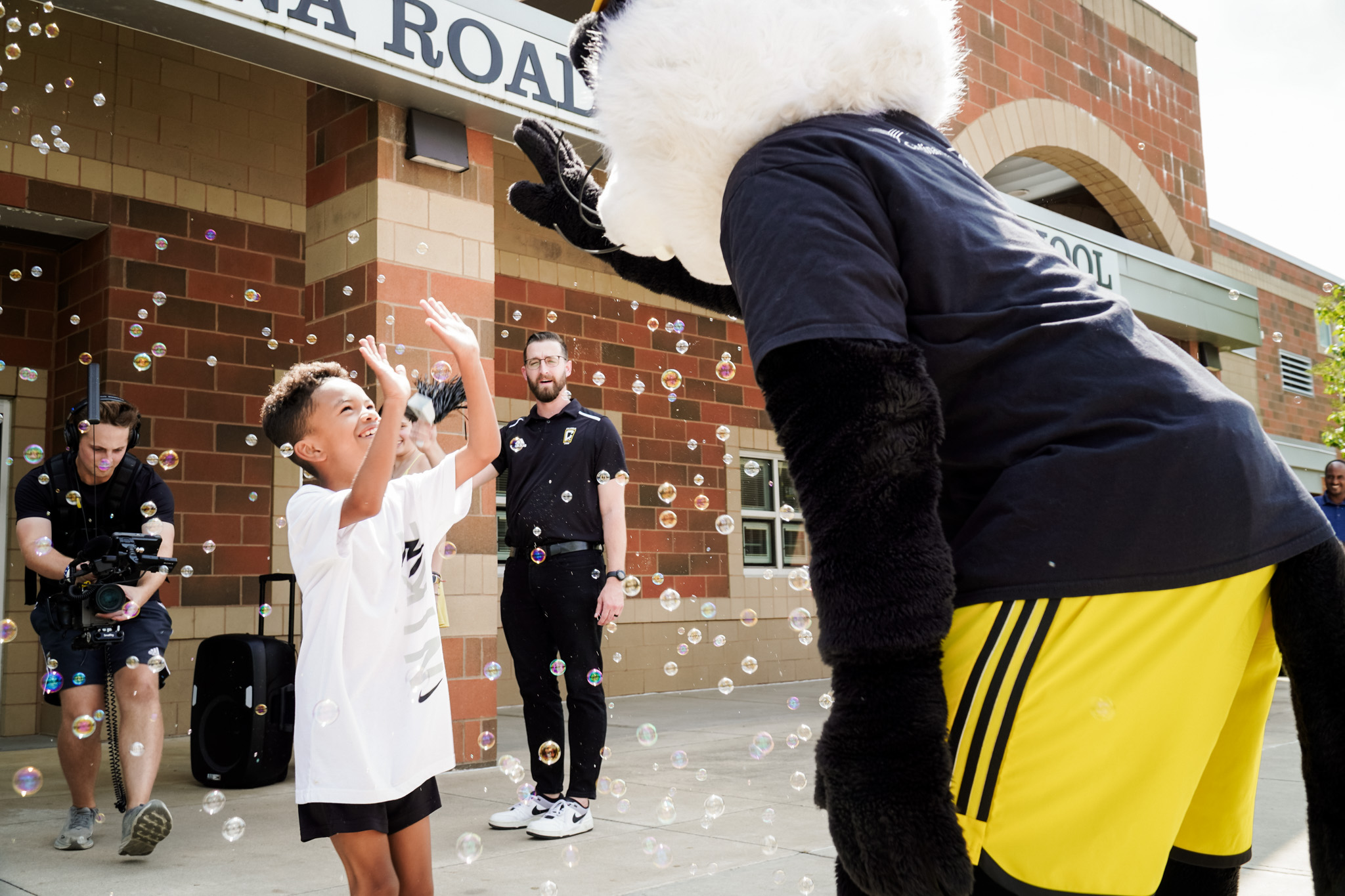 Stay in the Game mascot high-fiving a boy