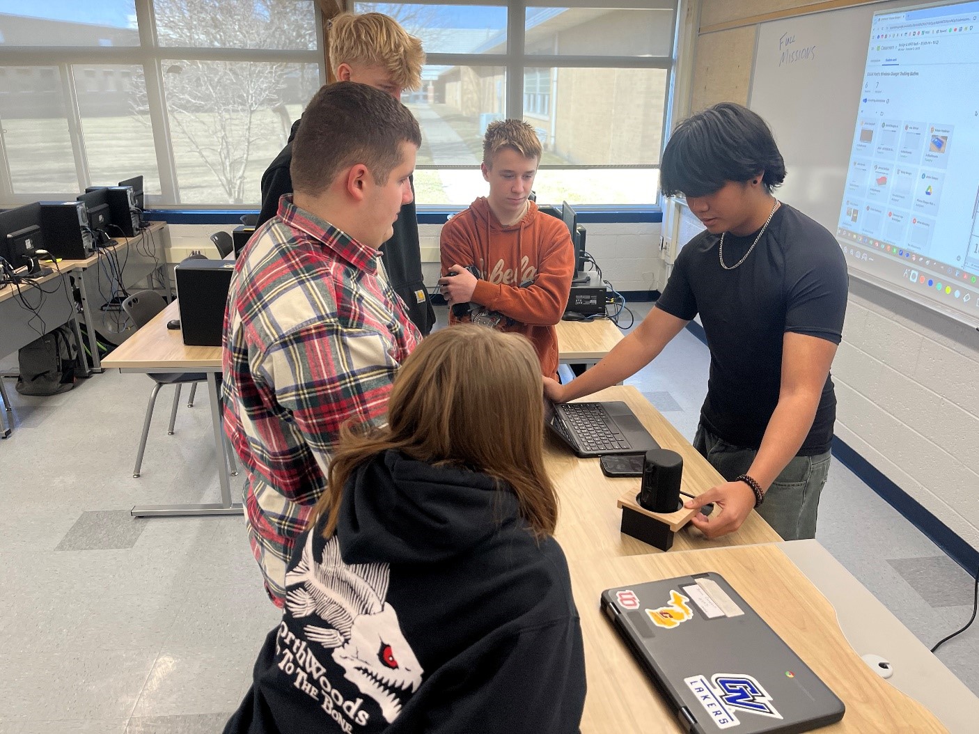 A group of kids working together while standing around a table