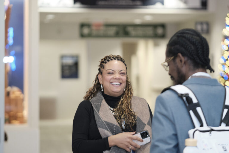 A woman laughing while talking with a colleague