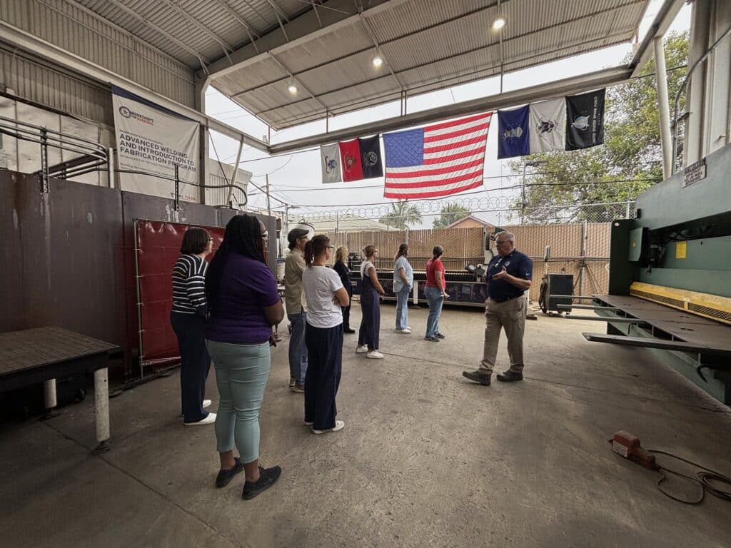 Educators tour a metal fabrication bay with an instructor during a California industry externship.