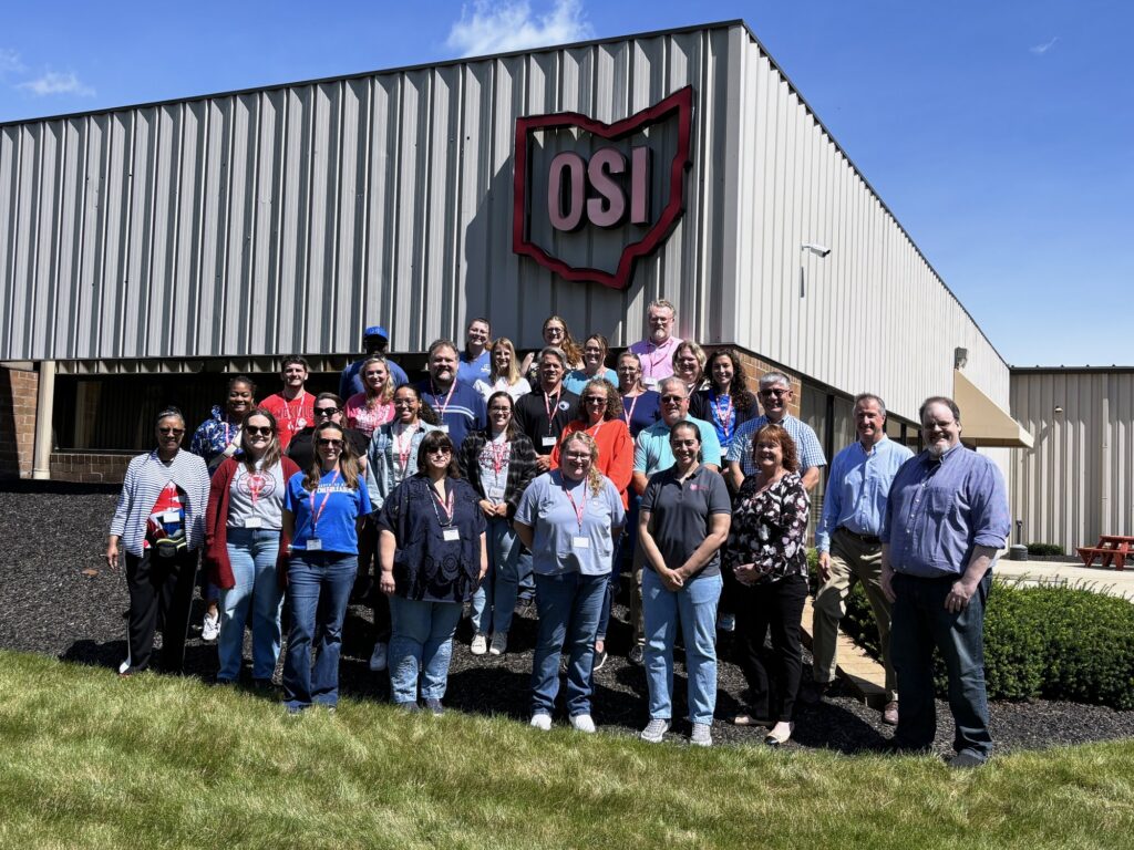 The Ohio Teacher Academy cohort stands together outside a partner manufacturing plant during a Year 4 site visit.