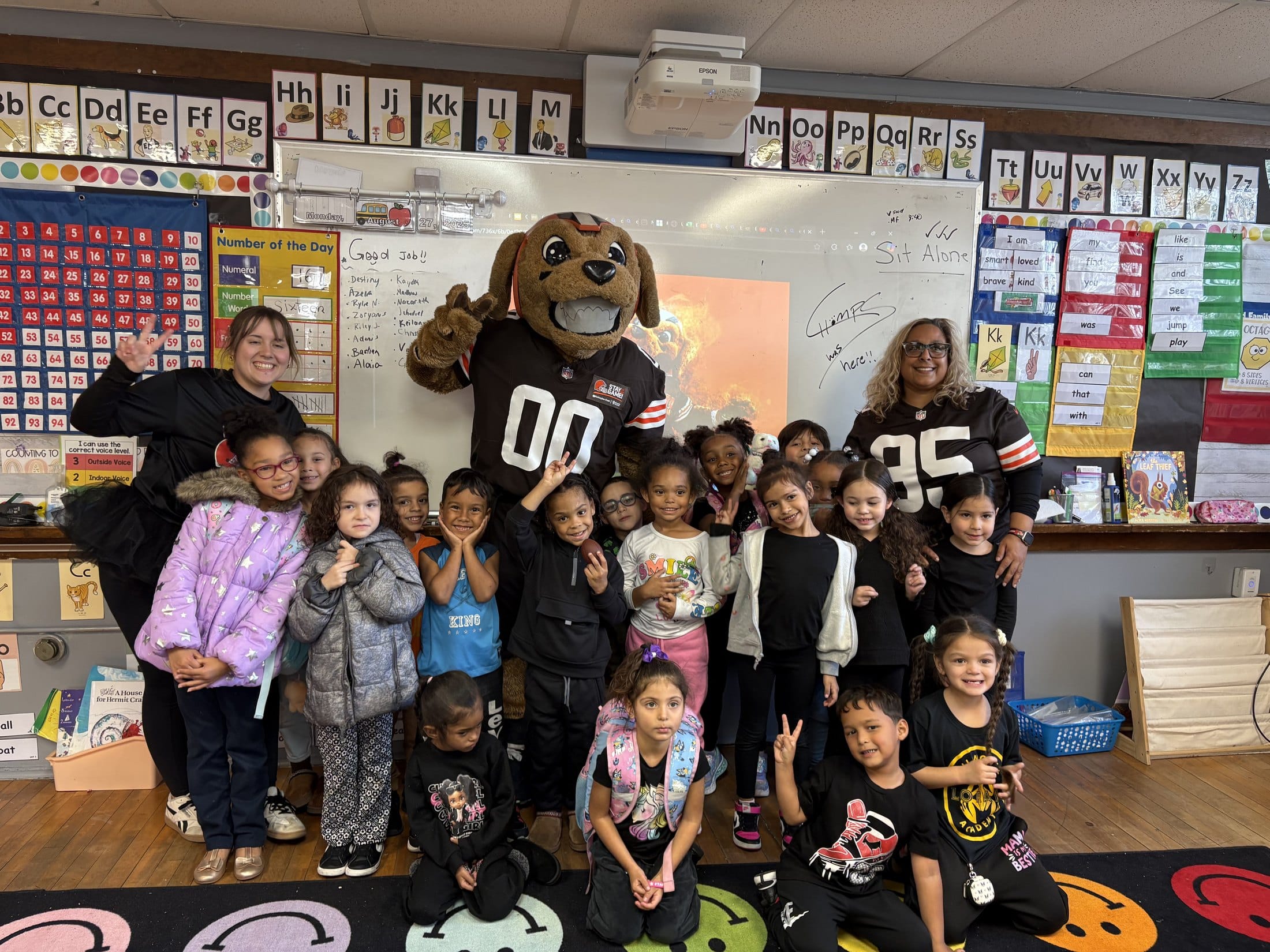 Lorain Bilingual Academy students celebrate with the Cleveland Browns mascot Chomps in their classroom.