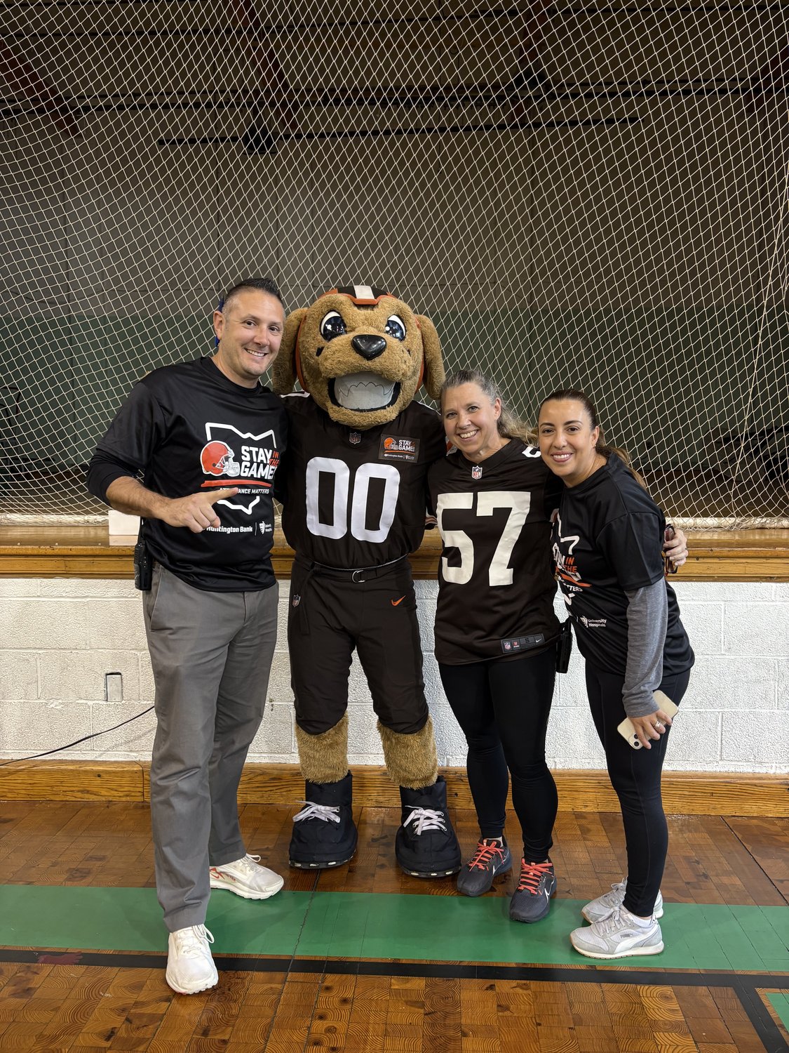 Lorain Bilingual Academy staff in Stay in the Game! gear with the Cleveland Browns mascot.
